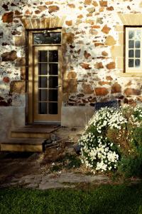 Little SwanportThe Shepherd's Cottage at Lisdillon Vineyard的一座石头建筑,前面有一扇门和鲜花