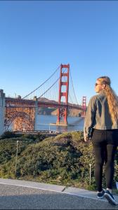 旧金山ITH San Francisco Pacific Tradewinds Hostel的桥前滑板上的女人