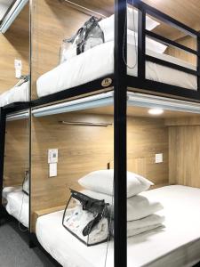 胡志明市Amango Dorm的客房配有4张双层床和白色枕头。