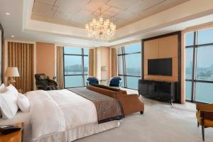 武汉武汉富力威斯汀酒店的一间卧室配有一张大床和一台平面电视