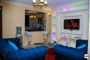 埃尔多雷特Denverwing Homes.的客厅配有2张蓝色沙发和电视
