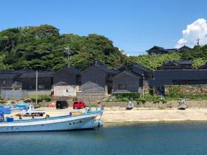 Hakuigun - House - Vacation STAY 14651的船坐在房子前面的水里