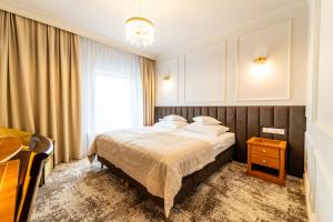 奥普尔皮亚斯特酒店的一间卧室配有一张床、一张桌子和一个窗户。