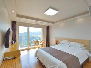 西归浦市Jeju Lavender Hotel的一间卧室设有一张床和一个大窗户