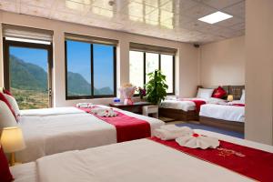 萨帕En Hotel Sapa的一间卧室配有三张红色和白色床单