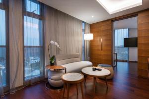 上海上海建滔诺富特酒店的客厅配有沙发、桌子和窗户