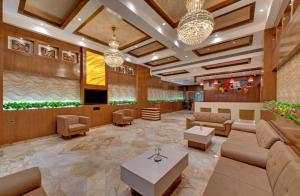 贾姆讷格尔Anaya Beacon Hotel, Jamnagar的大厅,设有沙发和桌子