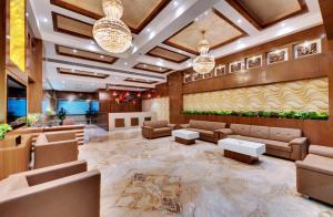 贾姆讷格尔Anaya Beacon Hotel, Jamnagar的大厅,设有沙发和桌子