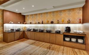 贾姆讷格尔Anaya Beacon Hotel, Jamnagar的厨房配有带许多锅碗瓢盆的柜台