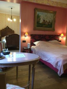 BaronvilleL'auberge的酒店客房配有一张床铺和一张桌子。