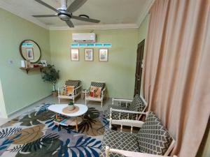古来Mini Green Homestay的客厅设有椅子、桌子和天花板