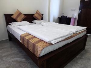 亭可马里尼悦旅馆的一张配有白色床单和枕头的大床