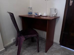 亭可马里尼悦旅馆的一张木桌,椅子放在房间里