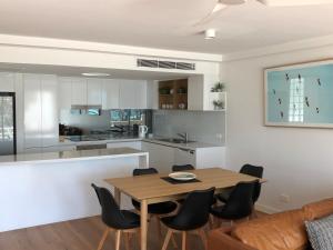 玛志洛卡马格海滨公寓的厨房以及带木桌和椅子的用餐室。