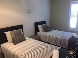 玛志洛卡马格海滨公寓的一间卧室设有两张床和窗户。