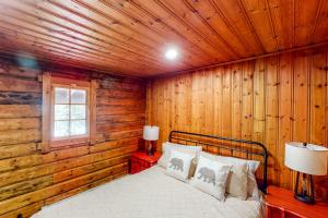 OtisHawks Eye Cabin的卧室配有木墙内的一张床