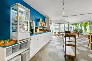 贝尔热拉克Logis Hôtel & Restaurant Ludik的厨房配有白色橱柜和蓝色的墙壁