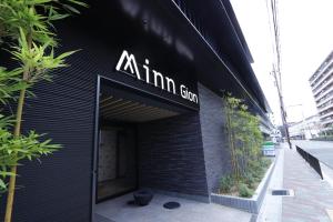 GiommachiMinn Gion的一座黑色的建筑,旁边有一个标志
