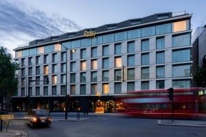 伦敦Ruby Zoe Hotel London的前面有一辆公共汽车的大建筑