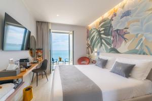 贾迪尼-纳克索斯Naxos Marina Bay的一间卧室配有一张大床、一张书桌和一个窗户。