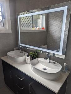 布里斯班Immaculate 2-Beds Entire House Chermside Brisbane的一间带两个盥洗盆和大镜子的浴室
