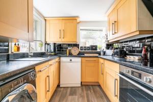 KentGorgeous Beach House的厨房配有木制橱柜和白色洗碗机。