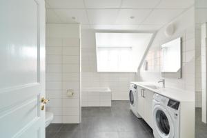 哥本哈根Beautiful 3 Bedroom Flat Near Shopping & Metro的白色的浴室设有洗衣机和水槽。