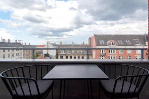 哥本哈根Beautiful 3 Bedroom Flat Near Shopping & Metro的阳台配有桌椅,享有建筑景致