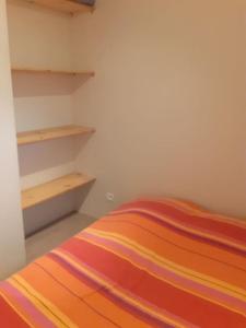 MontrodatLa cabane au fond du jardin的一间卧室配有一张带彩色条纹毯子的床