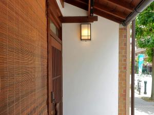 京都ALOHADAYS Kyoto的砖砌建筑的门,上面有灯