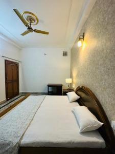 瓦拉纳西Paridhi的一间卧室配有一张大床和吊扇