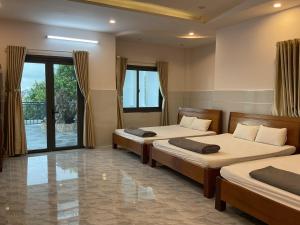 邦美蜀Hoàng Linh Hotel的一间卧室设有两张床和大窗户