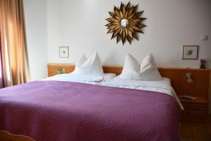 因斯布鲁克Villa Marwa - eine Ruheoase im Grünen的卧室配有一张紫色床,墙上设有镜子