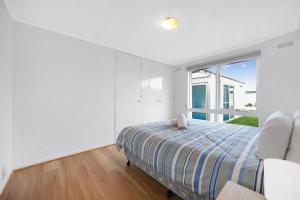 沃纳姆堡Logans Beach Apartments - Greenviews的一间卧室设有一张床和一个大窗户