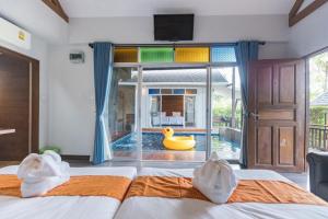乔木提恩海滩IP Plus Pool Villa Pattaya的卧室设有游泳池,窗户上放着橡皮鸭