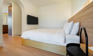 釜山Paul Mare Pool Villa的卧室配有白色的床和电视。