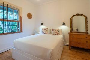 开普敦Snug Haven Cottage的一间卧室配有床、镜子和梳妆台