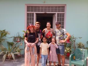 瓦拉纳西KANAK HOME STAY的家庭在房子前面为照片摆姿势