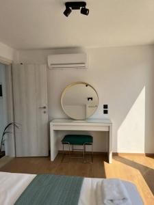 伊罗达Elounda Port Apartment的一间卧室配有镜子和桌椅