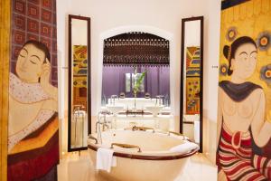 塔可克海滩Phulay Bay, A Ritz-Carlton Reserve的带浴缸的浴室以及墙上的绘画作品