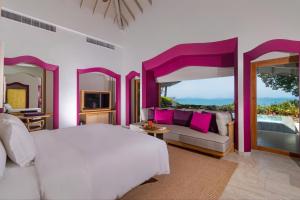 塔可克海滩Phulay Bay, A Ritz-Carlton Reserve的卧室配有白色的床和沙发