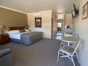 海伊绍布什汽车旅馆的卧室配有一张床和一张桌子及椅子