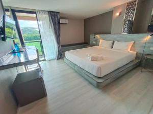 Ban Lan Dok Maiวัน บัดเจท เชียงราย เชียงแสน One Budget Hotel Chiangrai Chiangsaen的一间卧室设有一张大床和一个大窗户