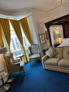 布莱顿霍夫Blue Sky Guest House的一间卧室配有一张床、一张沙发和一把椅子