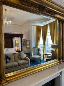 布莱顿霍夫Blue Sky Guest House的镜子反射着一间卧室,卧室配有一张床和一张沙发