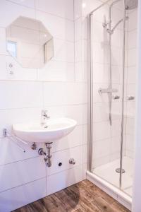 布劳恩拉格Hostel & Hotel Braunlage的白色的浴室设有水槽和淋浴。