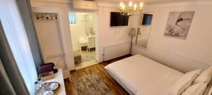 布拉索夫FIVE ROOMS的一间白色的小房间,配有床和镜子