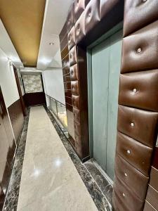 新德里Hotel Vista Inn, Karol Bagh, New Delhi - Near Metro的一间设有走廊、棕色和绿色墙壁的客房