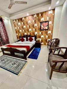 新德里Hotel Vista Inn, Karol Bagh, New Delhi - Near Metro的一间卧室配有一张床、两把椅子和地毯