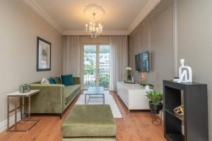 开普敦Green Point Luxury的客厅配有绿色沙发和电视